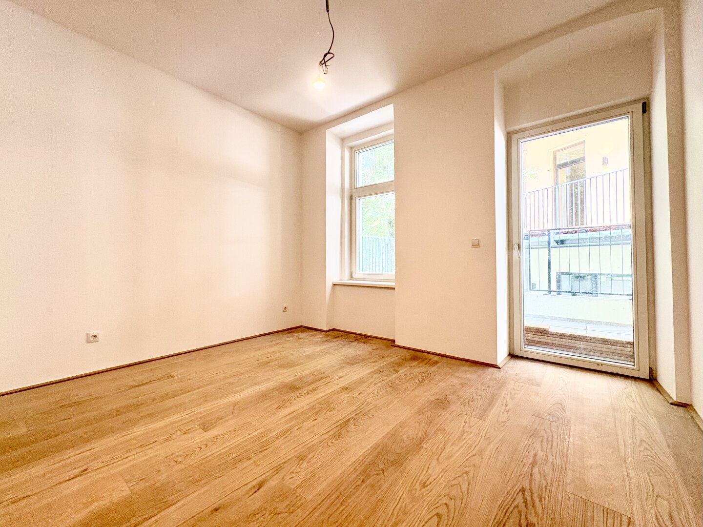 Heller Wohnraum mit Fenster und Balkontür, Top 1, Meiselstraße 9