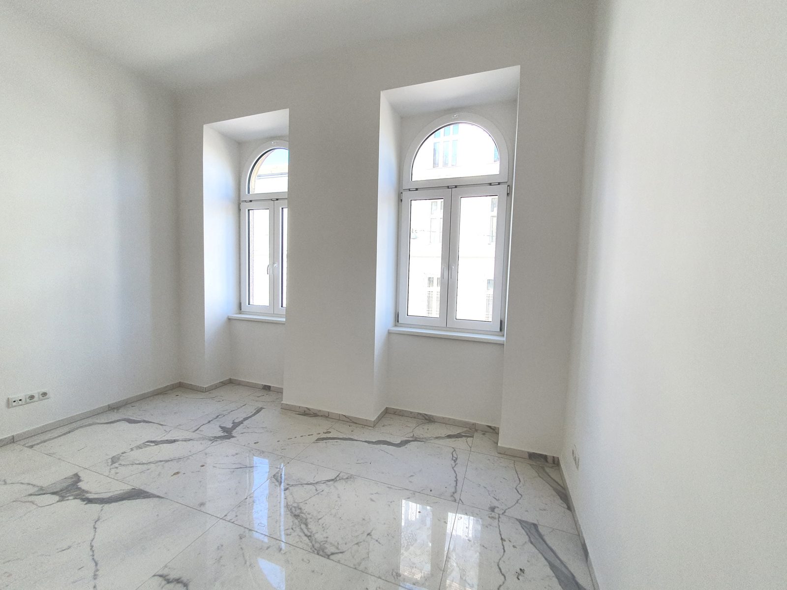 Wohnraum mit Rundbogenfenstern im sanierten Gründerzeithaus Hasnerstraße 99