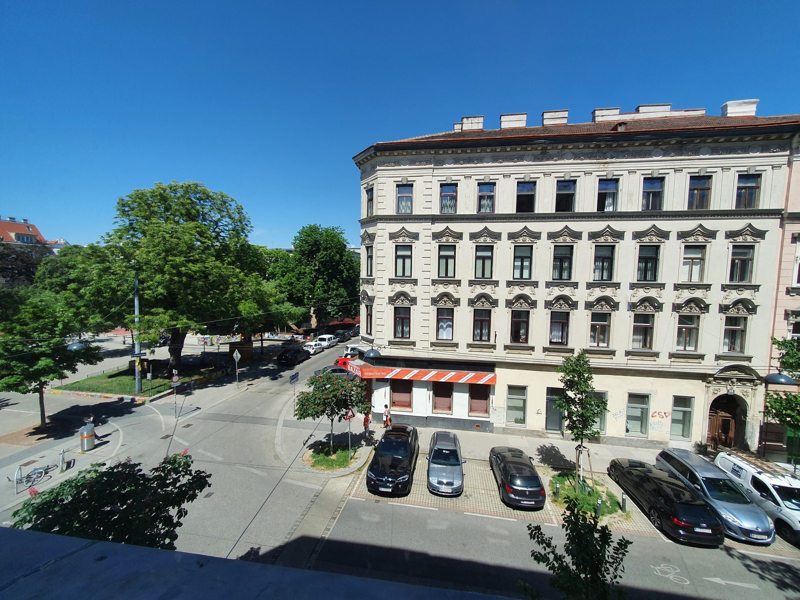 Blick aus der Hasnerstraße 99 auf die gegenüberliegende Häuserzeile und den Park