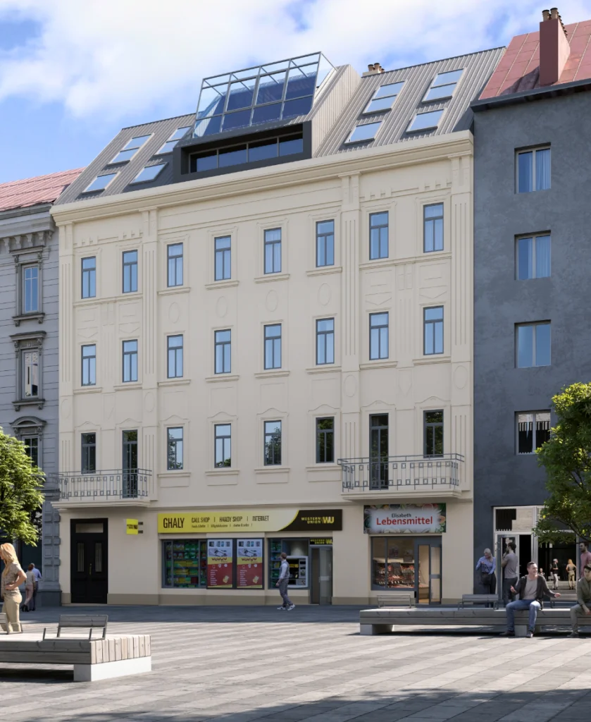 Saniertes Altbaugebäude mit hellem Putz, Geschäften im Erdgeschoss und Dachaufbau.